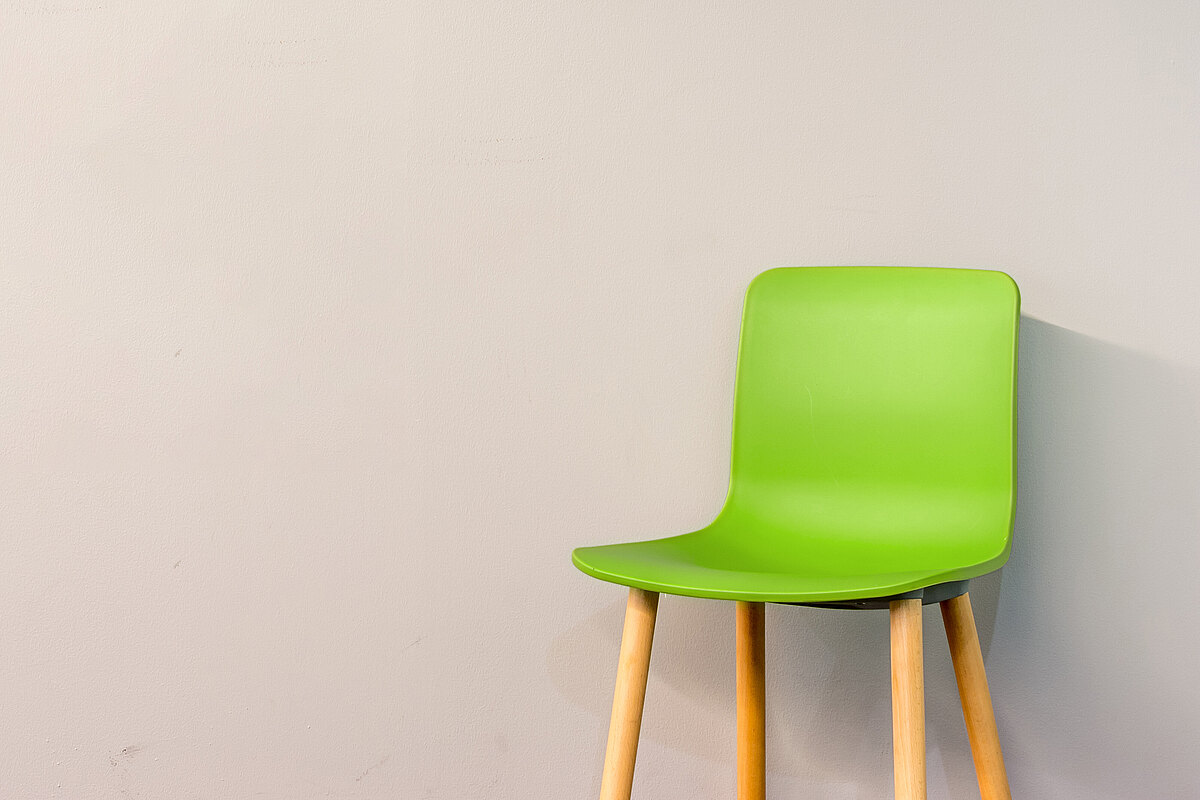 Grüner Stuhl mit hölzernen Beinen